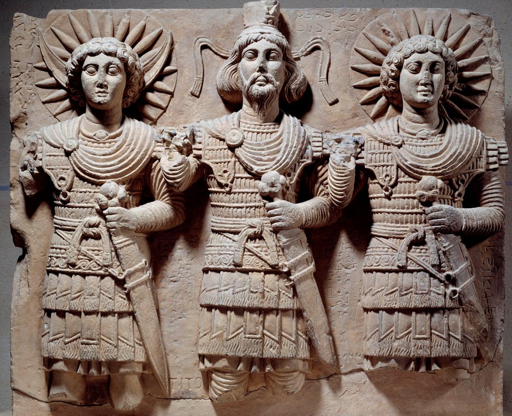 Triade palmirena: Baalshamin, signore del cielo tra il dio della luna e il dio del sole. Bassorilievo in calcare del I secolo. Da Palmira, Siria. Dimensioni: 0,6 x 0,72 m. Parigi, Musée du Louvre da Syrian