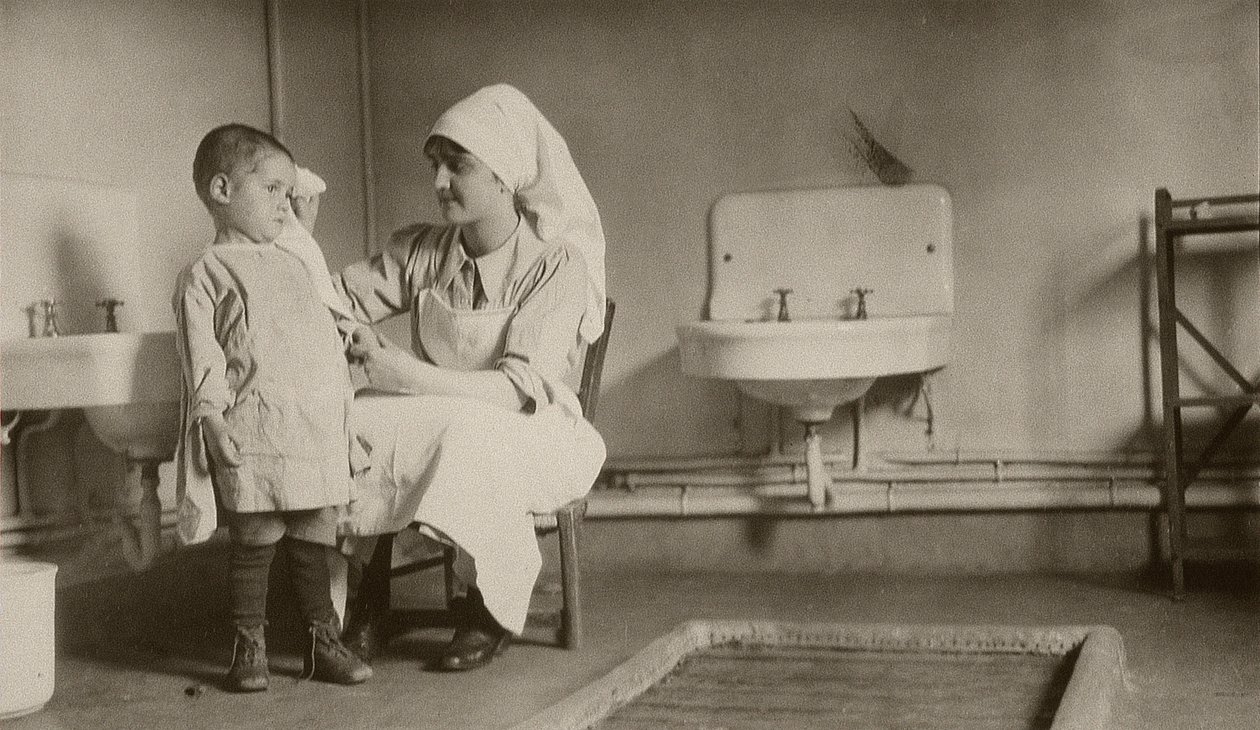 Infermiera che assiste un bambino malato nelle colonie di Passay e Saint-Quentin per rifugiati e orfani, 1919 da American Photographer