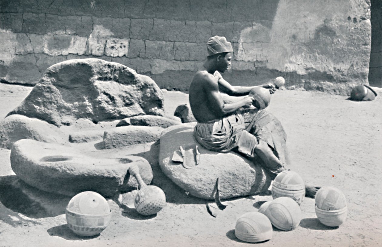 Un uomo Yoruba che incide ciotole di argilla e giare d