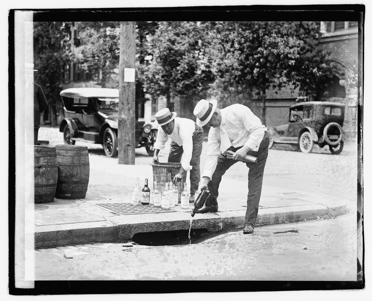 Due uomini che versano liquore in un tombino, 8 luglio 1921 (foto in bianco e nero) da American Photographer
