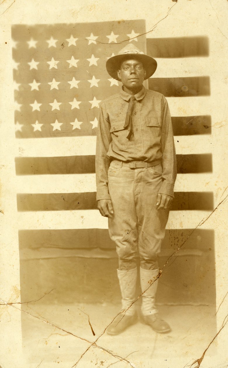 Soldato della Prima Guerra Mondiale con bandiera americana sullo sfondo, 1914-18 da American Photographer