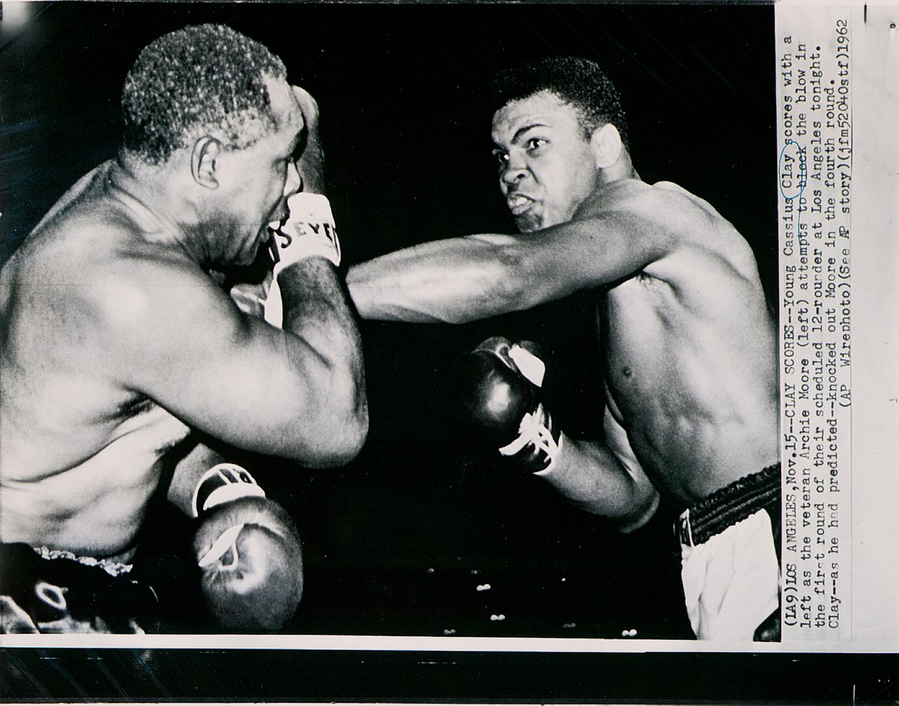 Il Giovane Cassius Clay colpisce con un sinistro il veterano Archie Moore nel primo round del combattimento a Los Angeles da American Photographer