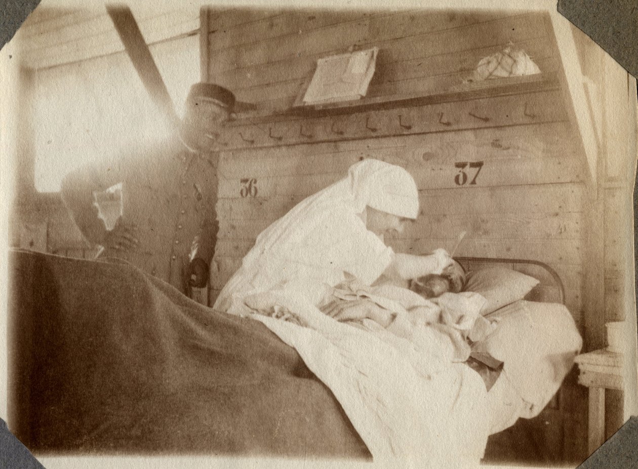 Prima Guerra Mondiale 1914-1918: infermiera in camice che rade un soldato (ferite di guerra francesi giacciono in un letto), a Couville, Manche, Bassa Normandia, Francia. Fotografia anonima luglio 1917. Collezione privata, Stella. da Anonymous Anonymous