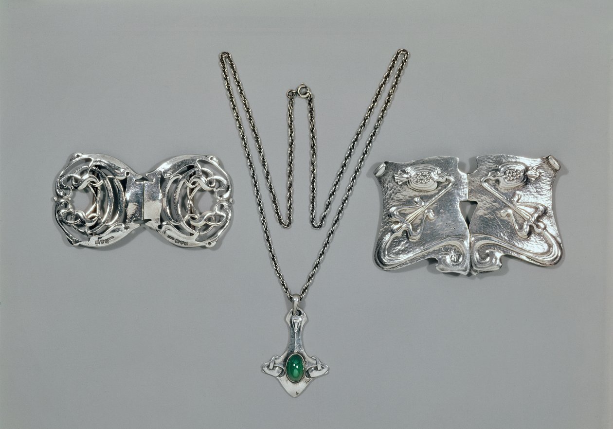Gioielli in argento progettati per Liberty. Da sinistra a destra: Fermaglio per vita con design celtico intrecciato, 1904. Pendente e catena con crisoprasio cabochon. Fermaglio per vita con design a rilievo su martellato da Archibald Knox