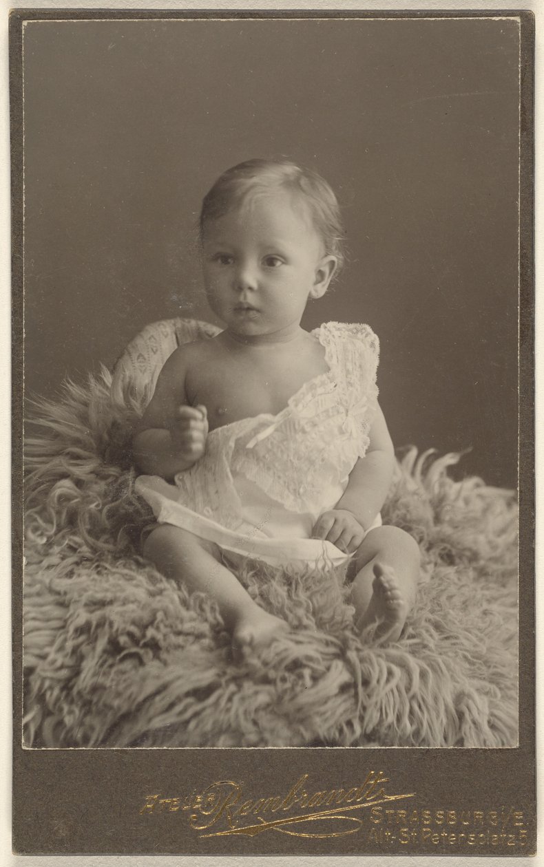 [Bambino non identificato seduto su un tappeto di pelle d