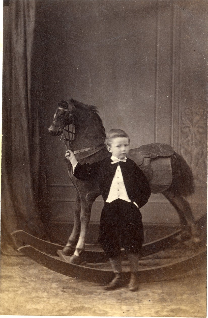 Ragazzo in piedi che tiene le redini di un cavallo a dondolo, anni 1860 da Barat