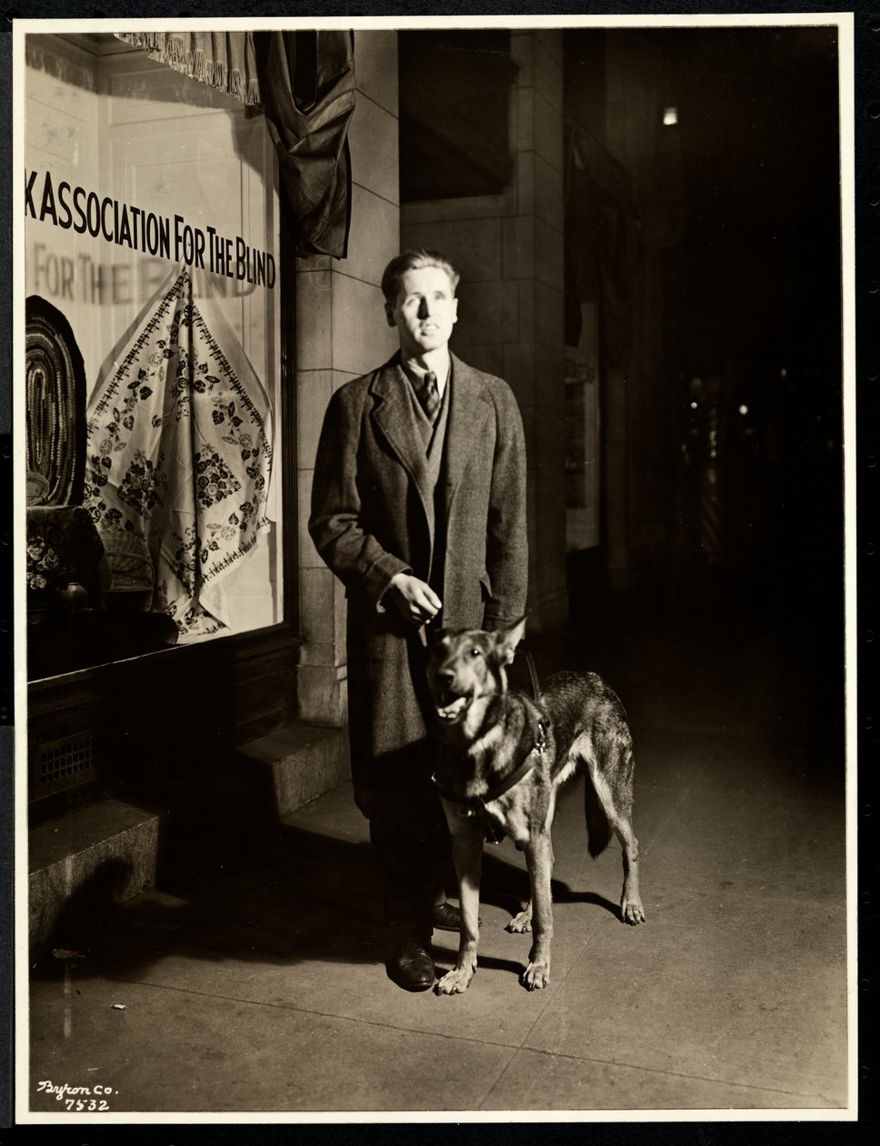 Uomo cieco e il suo cane guida sul marciapiede davanti alla New York Association for the Blind, 111 East 59th Street, New York, 1938 da Byron Company