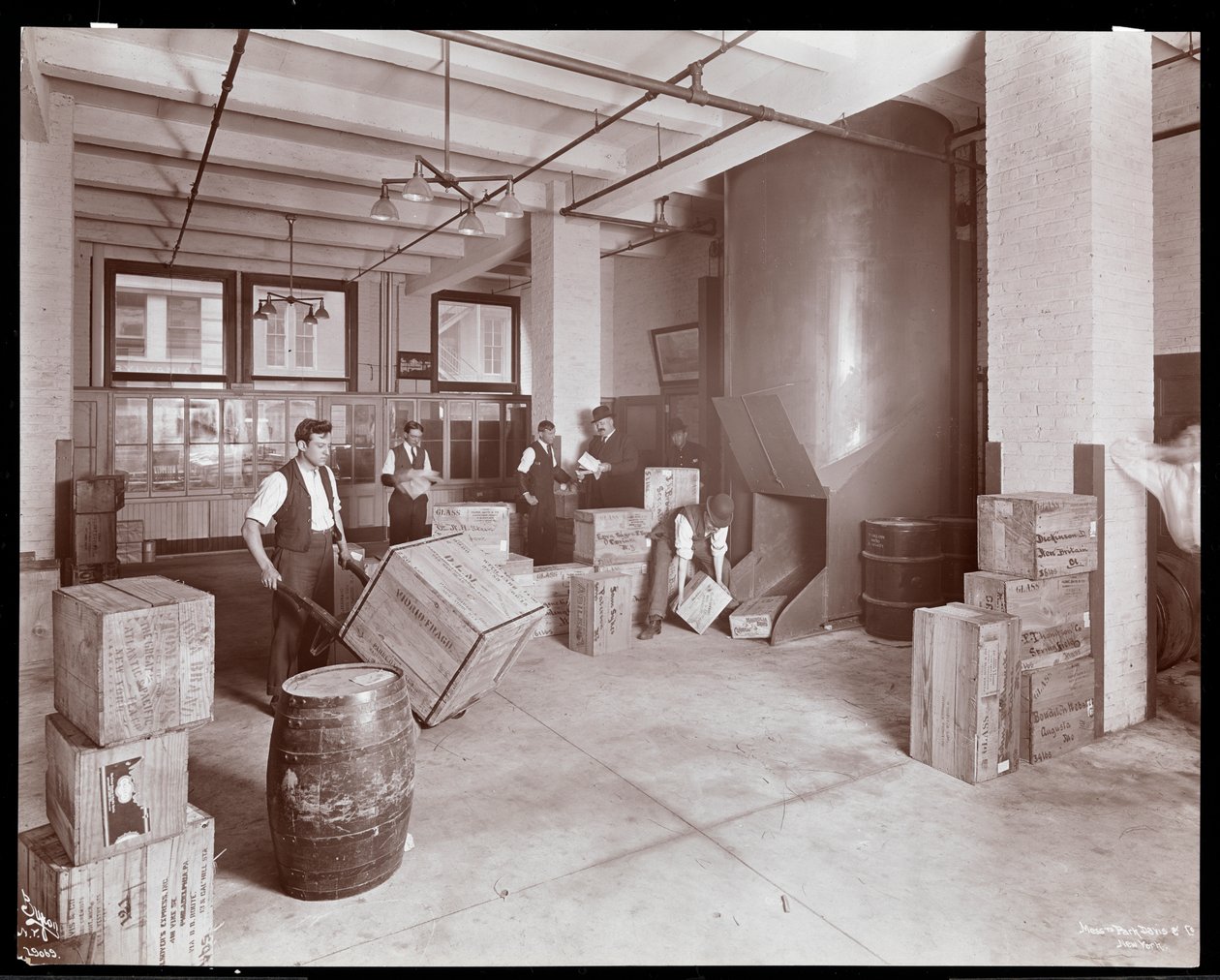 Uomini che lavorano con casse nel reparto spedizioni di Parke, Davis und Co., chimici, Hudson und Vestry Streets, New York, 1910 da Byron Company