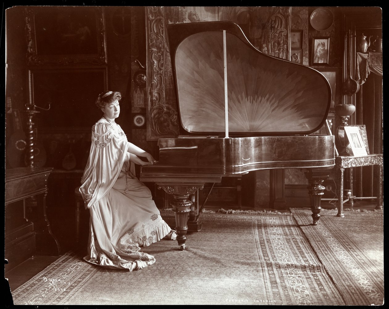 La signora I. M. Clark seduta a un pianoforte a coda, 1904 da Byron Company