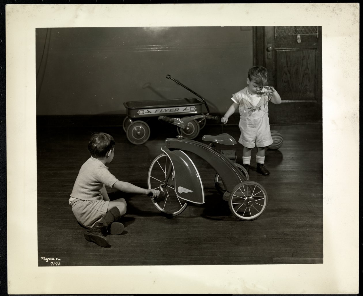 Due ragazzi non vedenti che giocano con un triciclo e un carretto rosso alla New York Association for the Blind, 111 East 59th Street, New York, 1937 da Byron Company