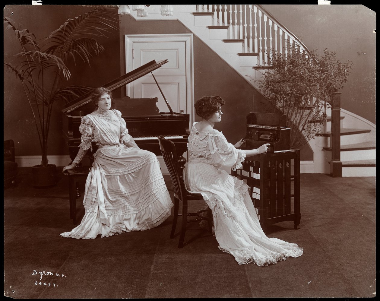 Due donne con un pianoforte e attrezzatura di registrazione da Byron Company