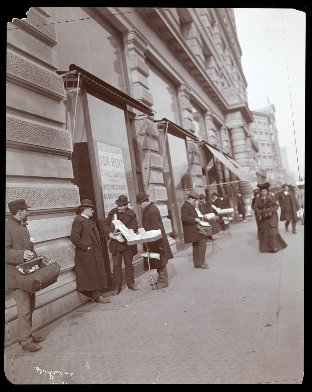 Veduta dei venditori ambulanti che vendono giocattoli e altri oggetti davanti al Fuller o Flatiron Building a Broadway, 5th Avenue e 23rd Street, New York, c.1895 da Byron Company
