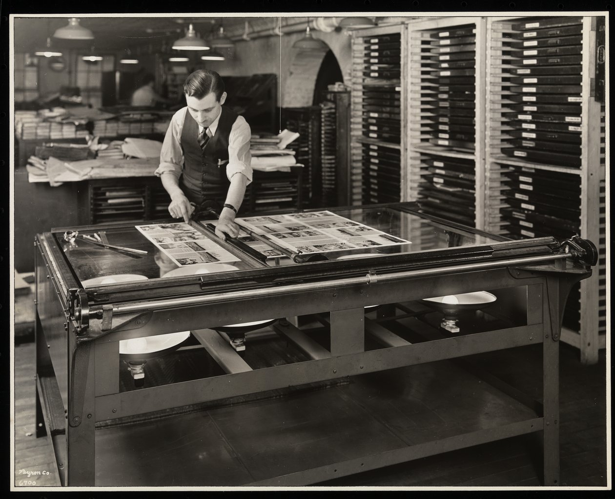 Lavorare su un layout a un tavolo luminoso presso Unz und Co., 24 Beaver Street, New York, 1932 da Byron Company