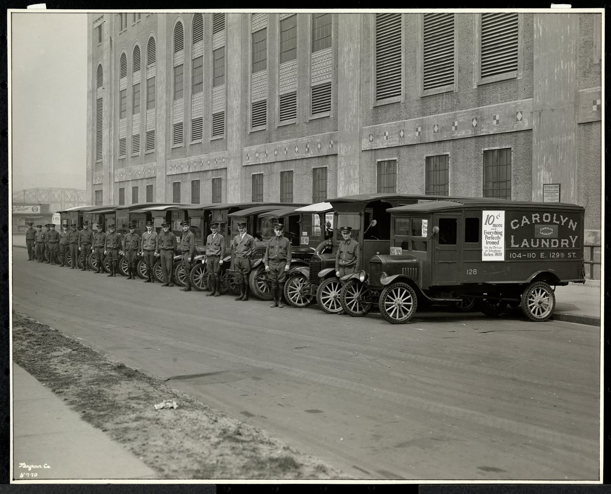 Una fila di camion di consegna parcheggiati fuori dalla Carolyn Laundry a 111 East 128th Street, East Harlem, New York, 1929 da Byron Company