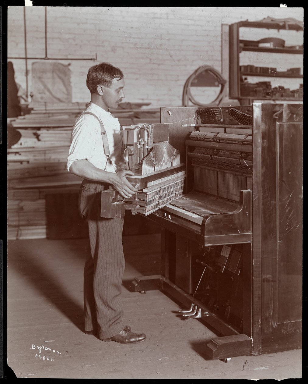 Uomo che lavora nella fabbrica di pianoforti Hardman, Peck und Co., New York, 1907 da Byron Company