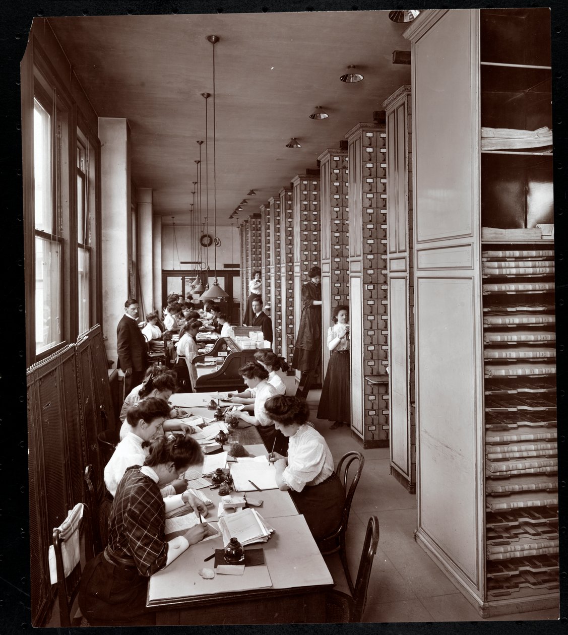 Donne che lavorano in un archivio, sotto supervisione maschile, presso la Metropolitan Life Insurance Co. in 23rd Street e Madison Avenue, New York, 1907 da Byron Company