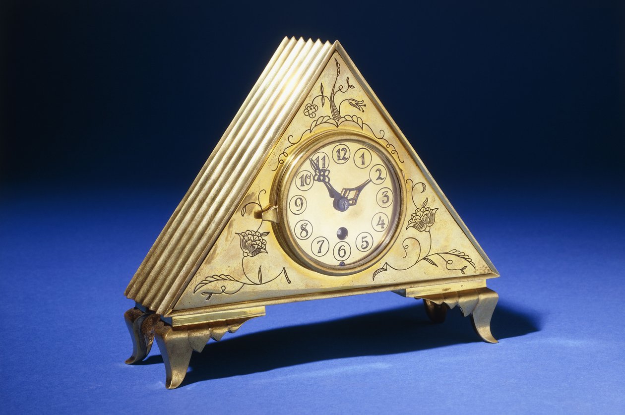 Orologio da tavolo triangolare in ottone con decorazione floreale incisa da Dagobert (attr. to) Peche