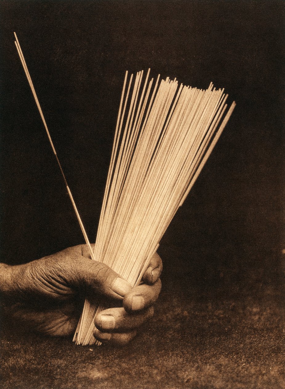 Primo piano della mano di un indiano della tribù o villaggio Hupa che tiene bastoncini di divinazione da Edward Sheriff Curtis