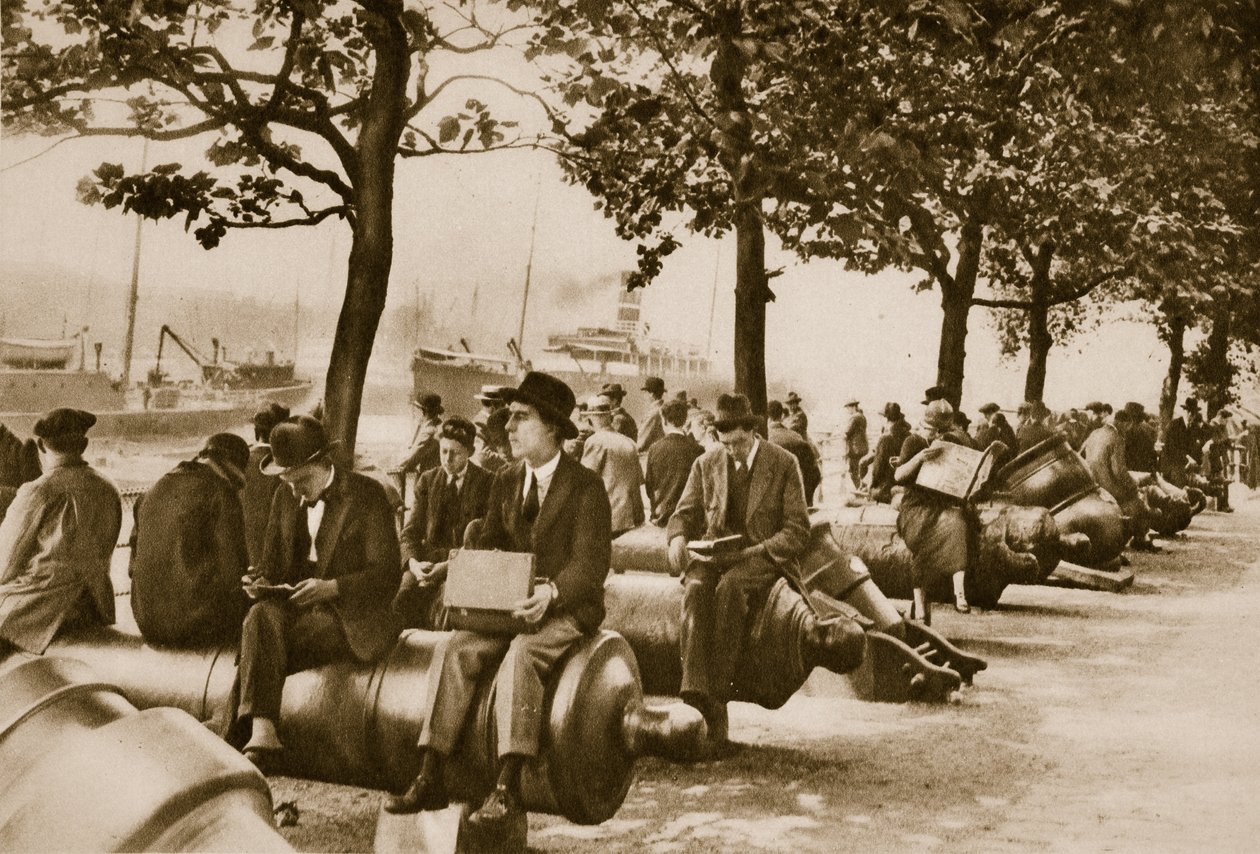 Lavoratori della città pranzano a Tower Wharf, seduti su vecchi cannoni da English Photographer