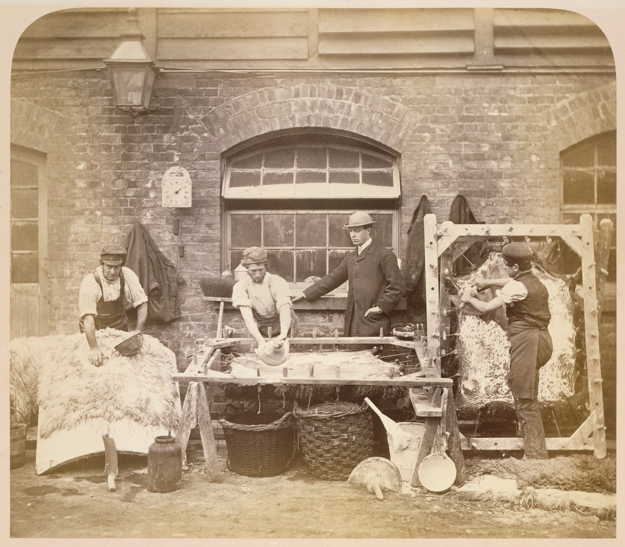 Lavoratori che fanno tappeti di pelle di pecora da English Photographer