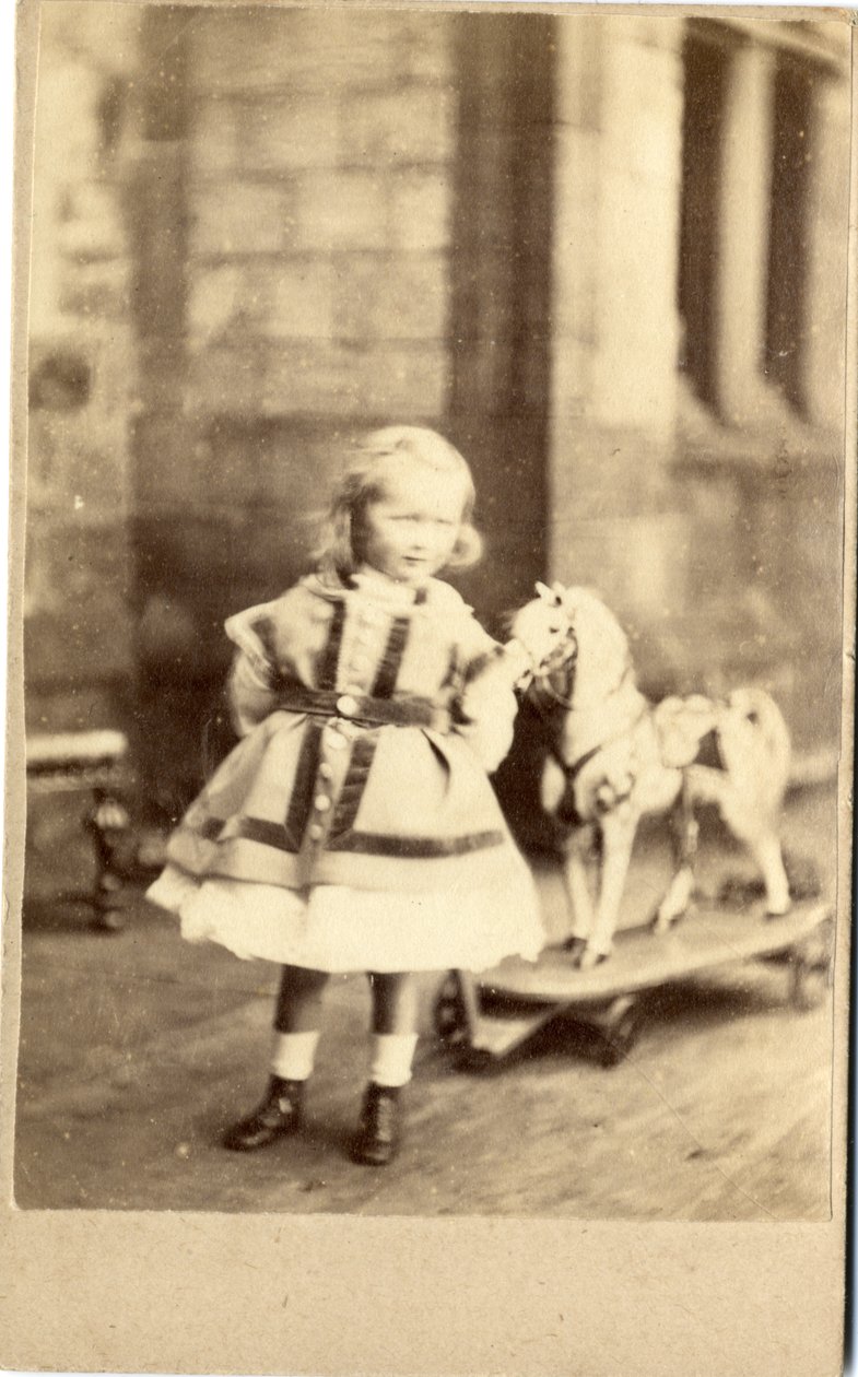 Ragazza con il suo cavallo giocattolo da English Photographer