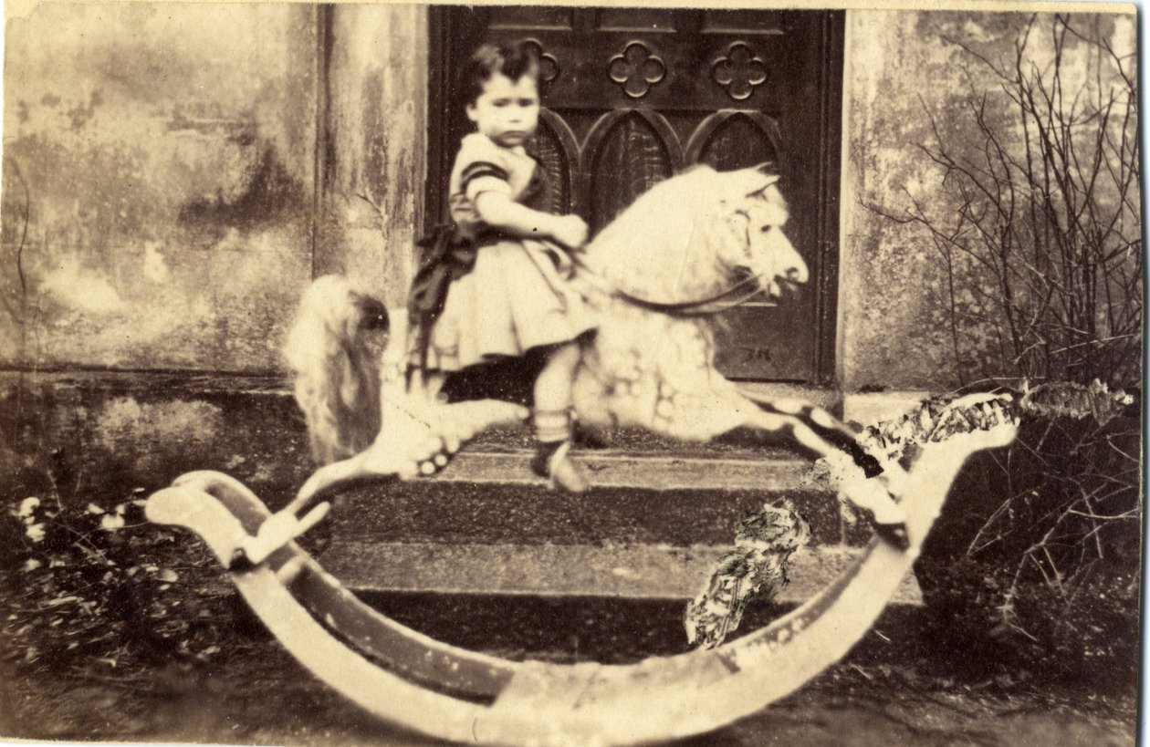 Bambina su un grande cavallo a dondolo in un giardino, 1860s da English Photographer