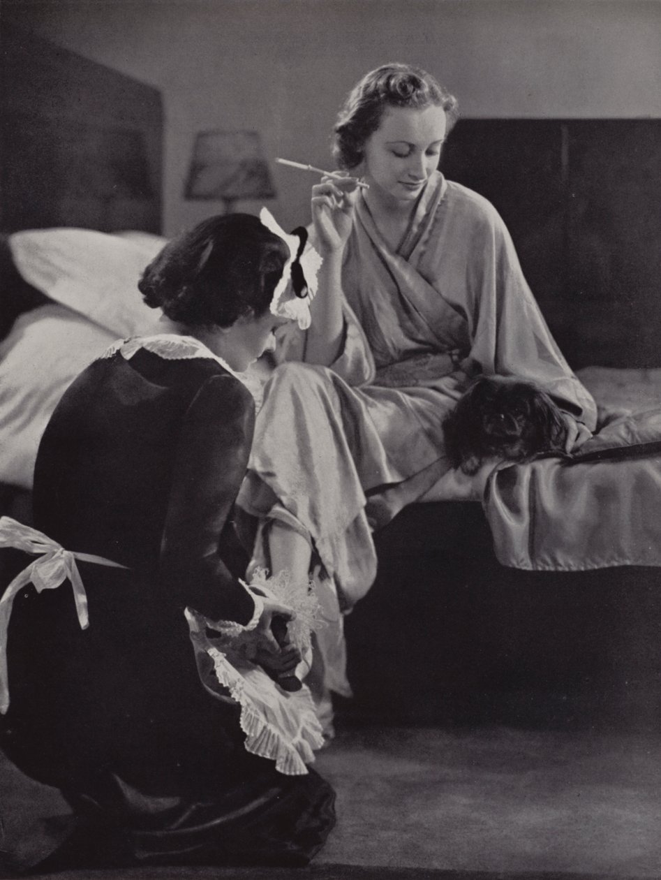 Donna aiutata a vestirsi al mattino dalla sua cameriera, Mayfair, Londra (foto b/n) da English Photographer