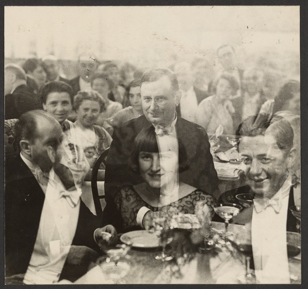 [Doppia esposizione di un gruppo di persone a un banchetto]. da Erich Salomon