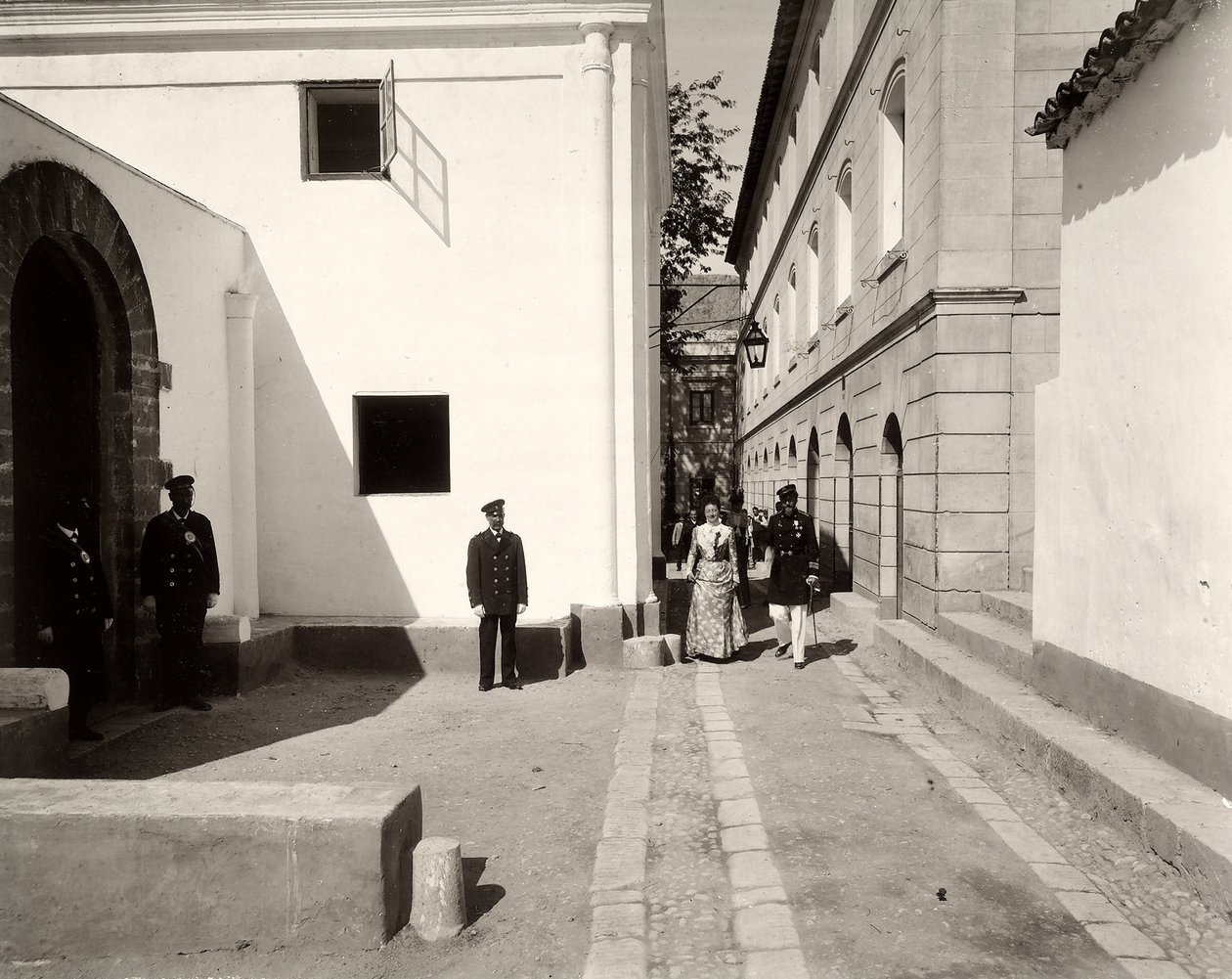 Uomini in uniforme che accompagnano una donna elegantemente vestita verso la chiesa della fattoria di Lo Zucco, Sicilia, 1900 da Eugenio Interguglielmi
