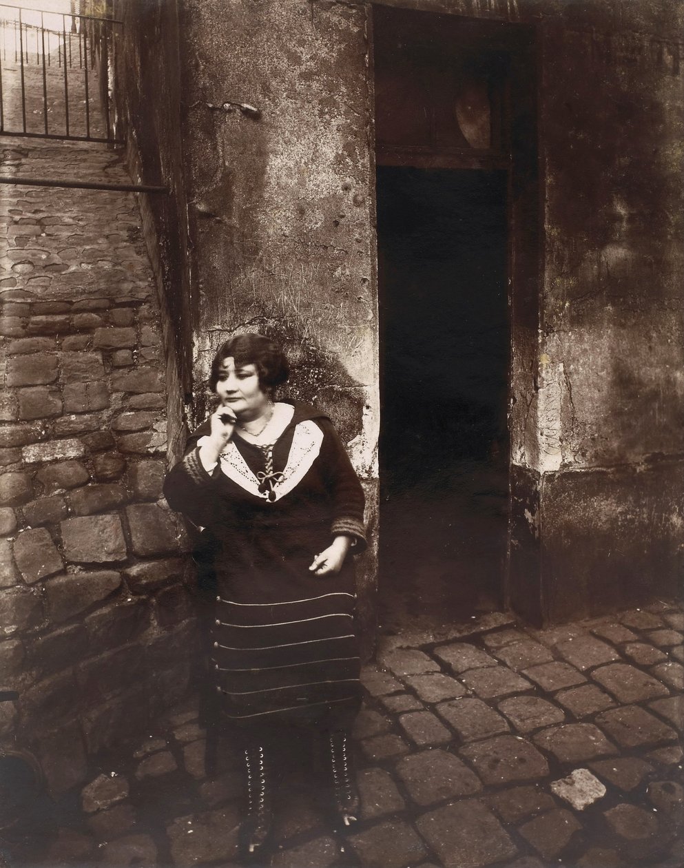 La Villette. Rue Asselin, prostituta che aspetta davanti alla sua porta da Eugène Atget