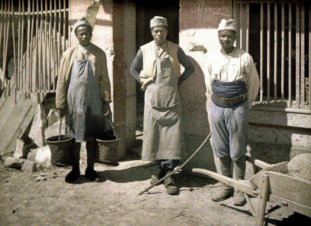 Tre lavoratori del Senegal davanti a una casa, Soissons, Aisne, Francia, 1917 da Fernand Cuville