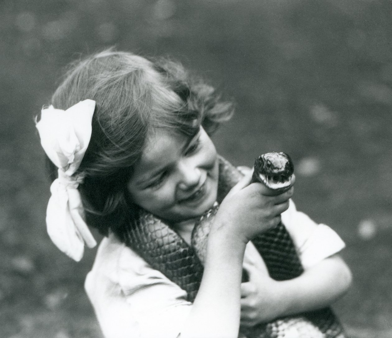 Una giovane ragazza Betty che tiene un serpente indaco orientale, Zoo di Londra, 1924 da Frederick William Bond