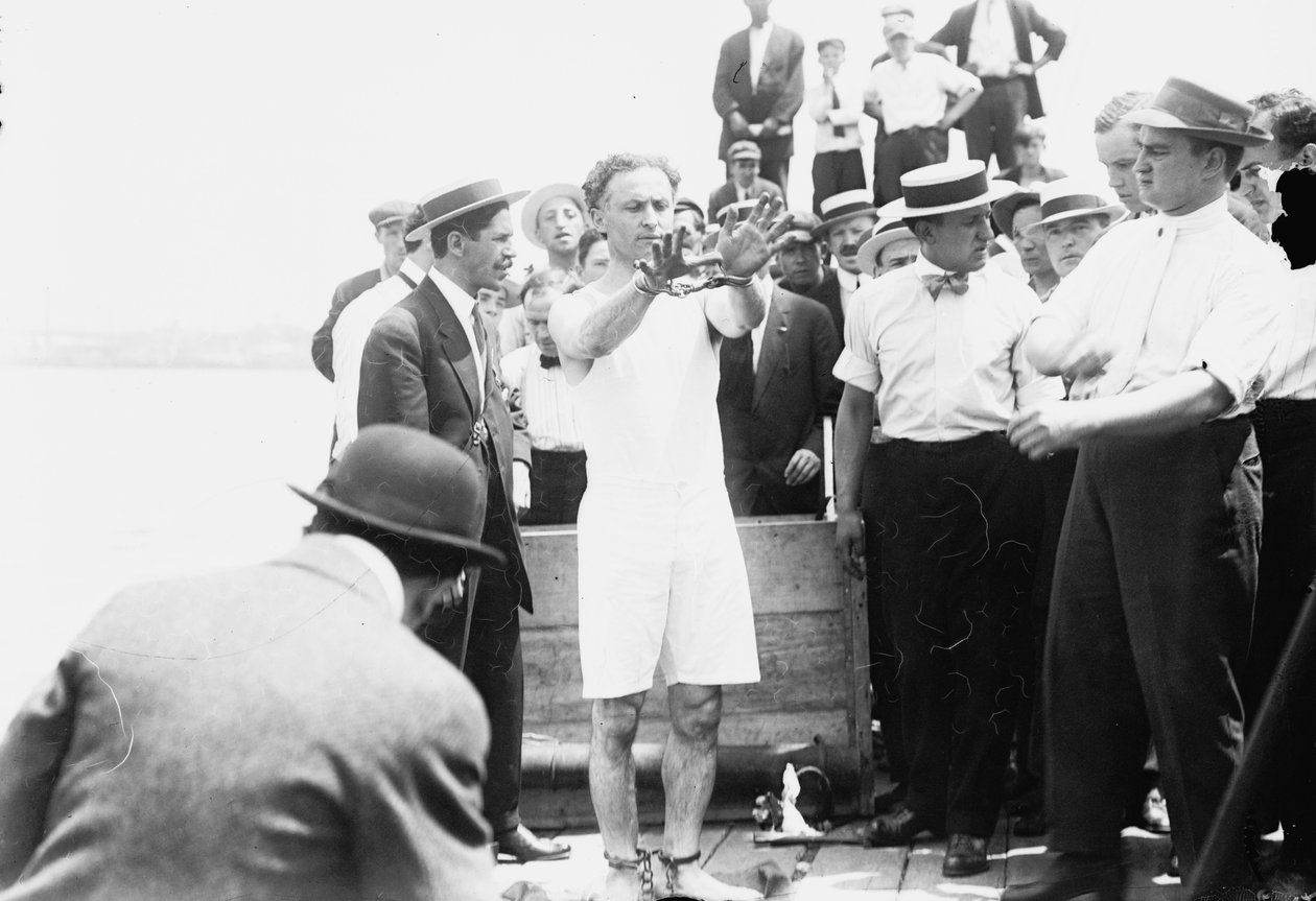 Harry Houdini ammanettato prima di essere chiuso in una cassa e calato nella baia di New York, 1912 da George Grantham Bain