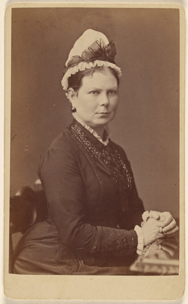 Donna non identificata con cuffia ornata da un fiocco, seduta con le mani unite da George Washington Wilson