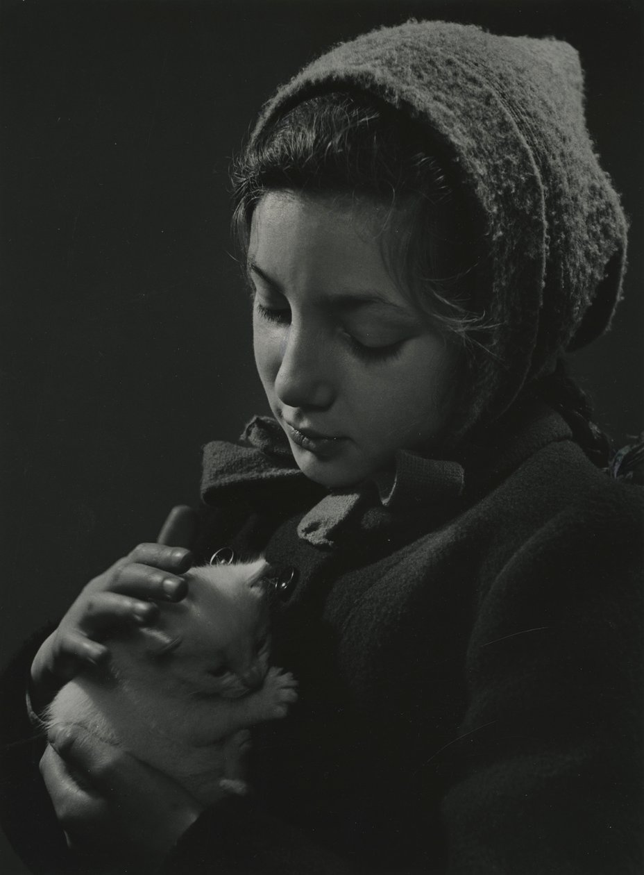 Ragazza che tiene in braccio un gattino bianco. Primi anni 