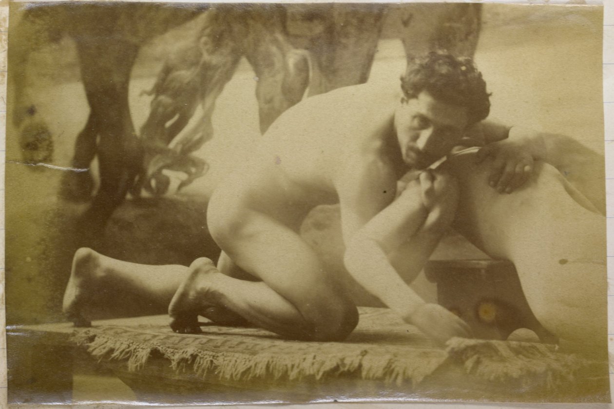Studio di un modello maschile nudo, sdraiato a terra e lottando con un manichino, nell