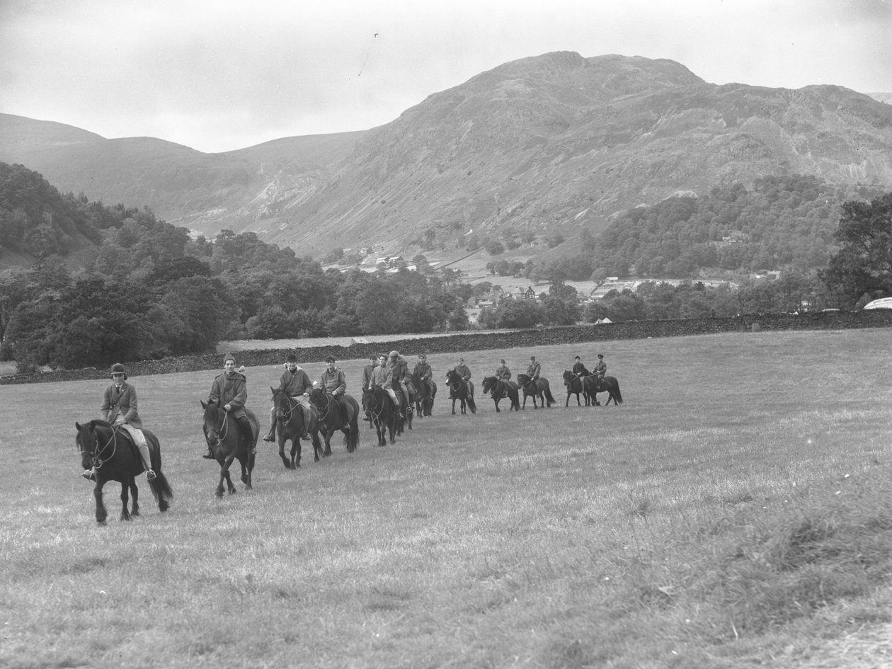 Un gruppo di uomini che fanno trekking in fila sui pony, sullo sfondo i campi da golf da Joseph Hardman