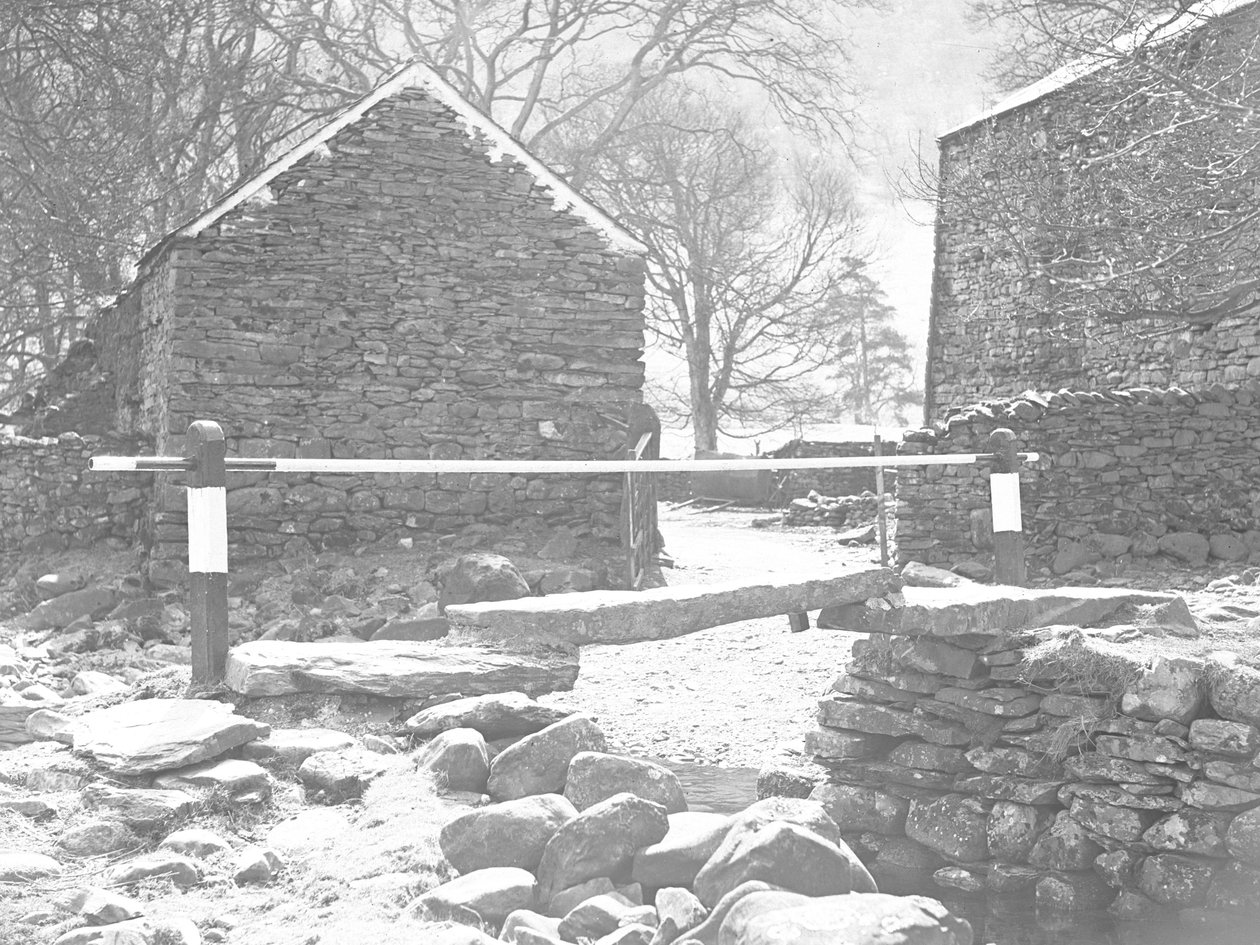 Ponte in lastre di pietra e corrimano che attraversa un ruscello con alle spalle dei farmbuidling da Joseph Hardman