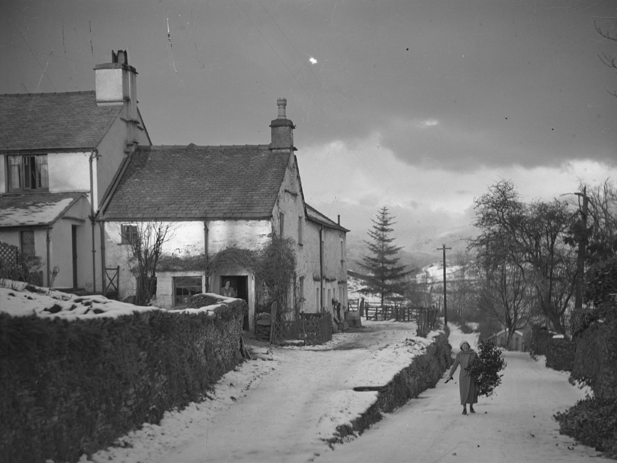 Donna che trasporta rami sulla strada accanto alla fattoria Borwick Fold di Hawkshead sotto la neve da Joseph Hardman