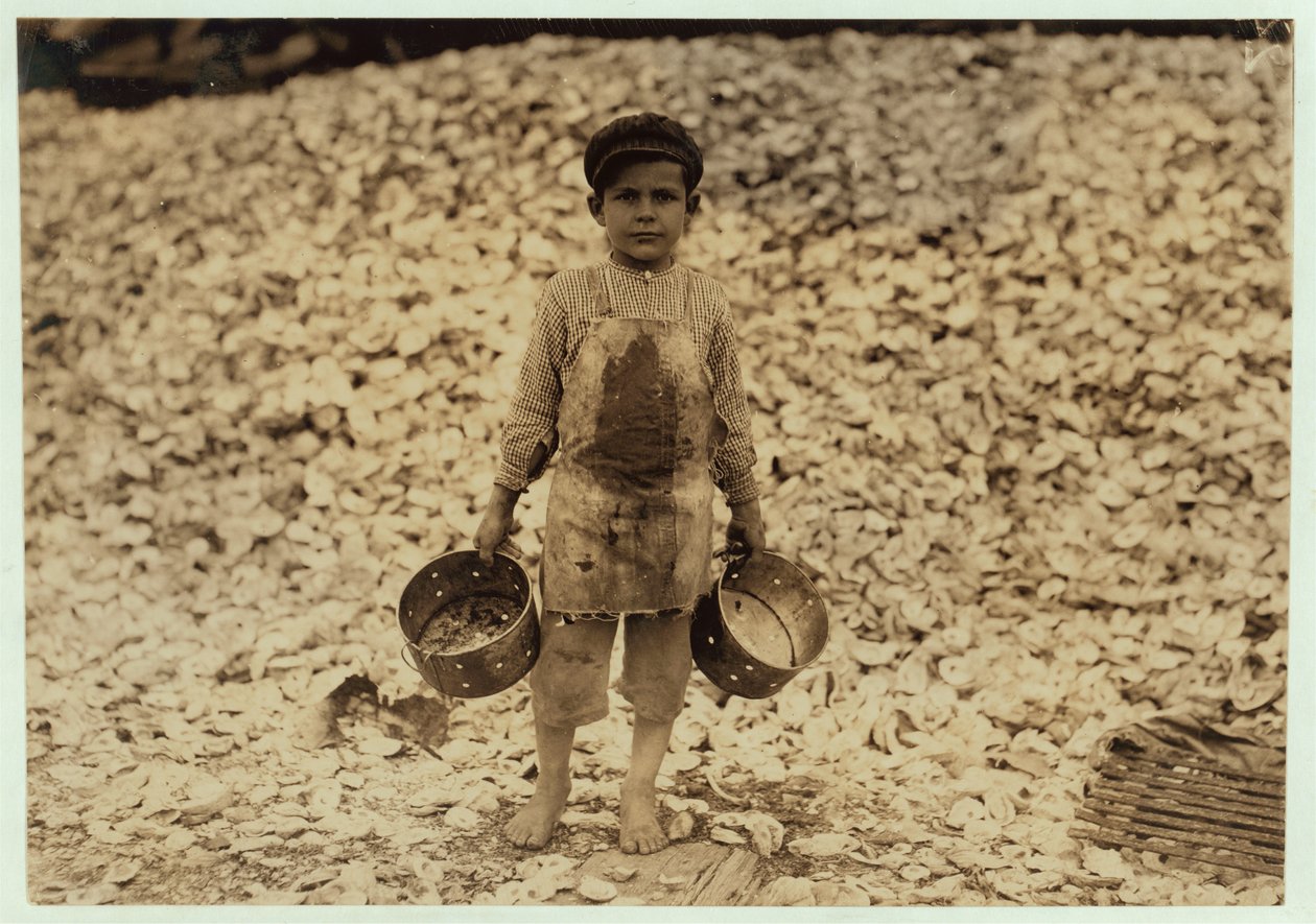 Manuel, raccoglitore di gamberetti migrante di 5 anni, davanti a un mucchio di gusci di ostriche, lavorando per il secondo anno alla Dunbar, Lopez, Dukate Company, Biloxi, Mississippi, 1911 da Lewis Wickes Hine