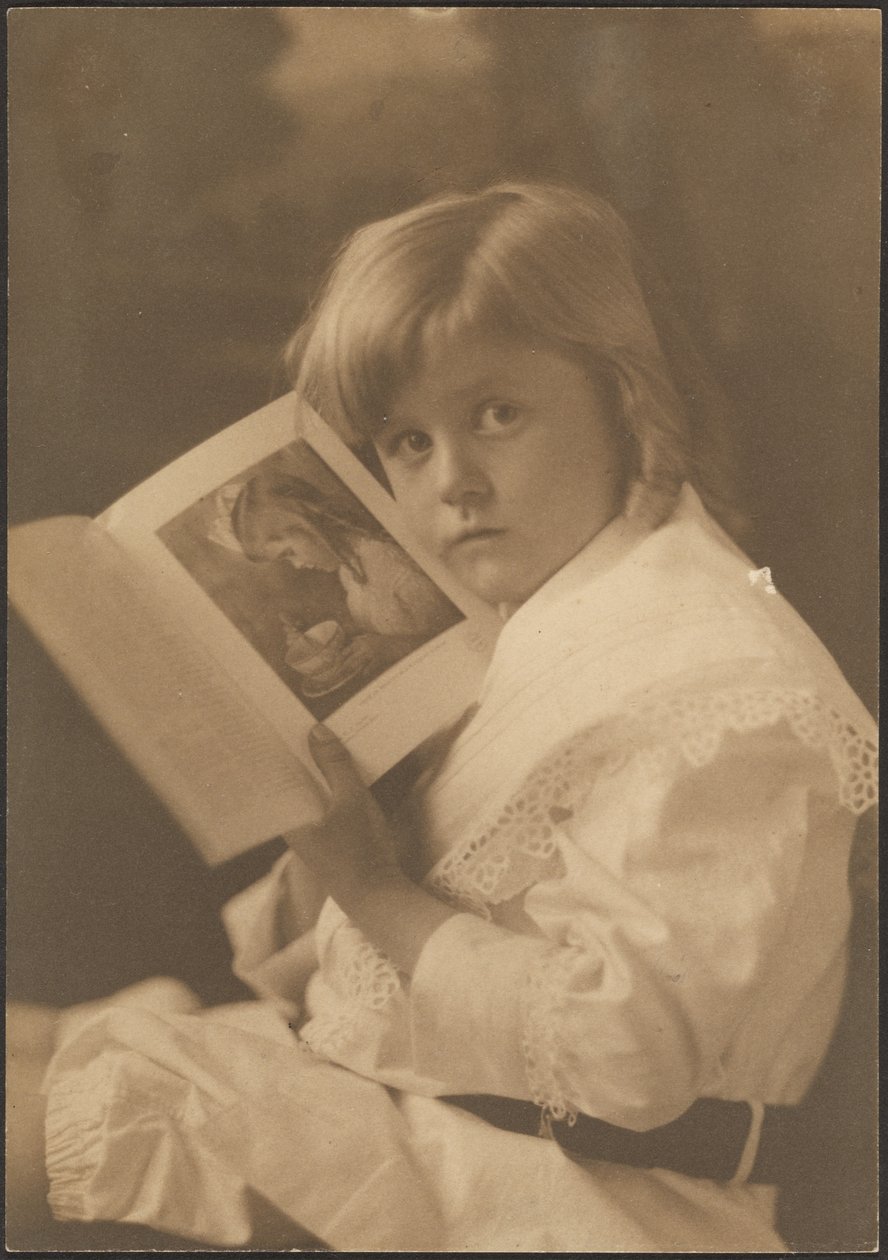 [Ritratto di un bambino che tiene un libro aperto su un