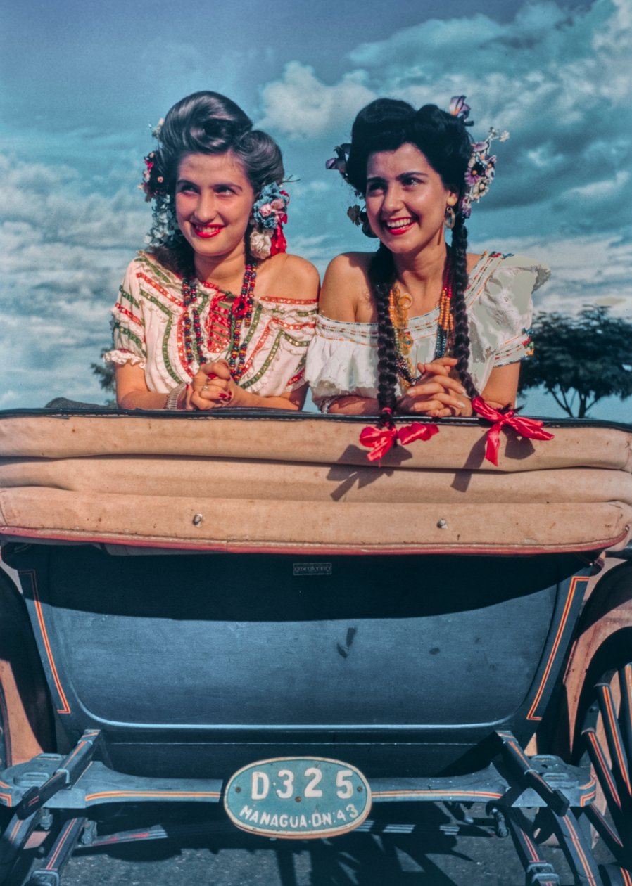 Giovani donne nicaraguensi posano in costumi festivi e copricapi sul retro di una carrozza da Luis Marden