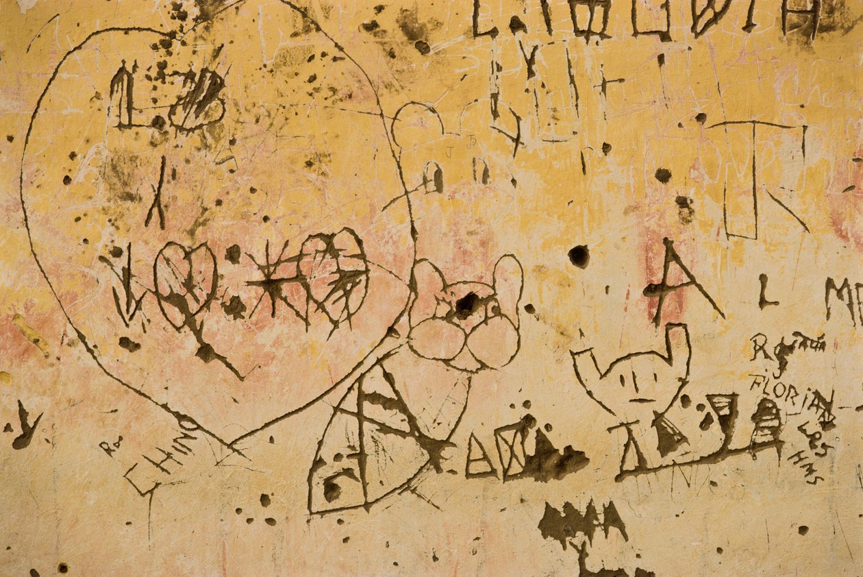 Graffiti incisi su un vecchio muro di intonaco esterno da Nathan Benn