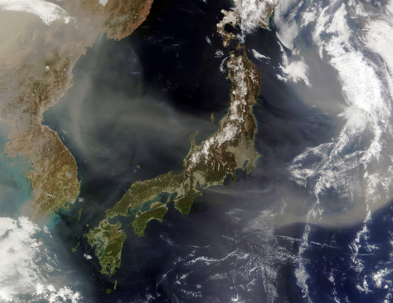 Vista satellitare del Giappone con montagne innevate, terre verdi in primavera a livelli inferiori. Polvere dalla Cina continentale che soffia sul Mar del Giappone e nell