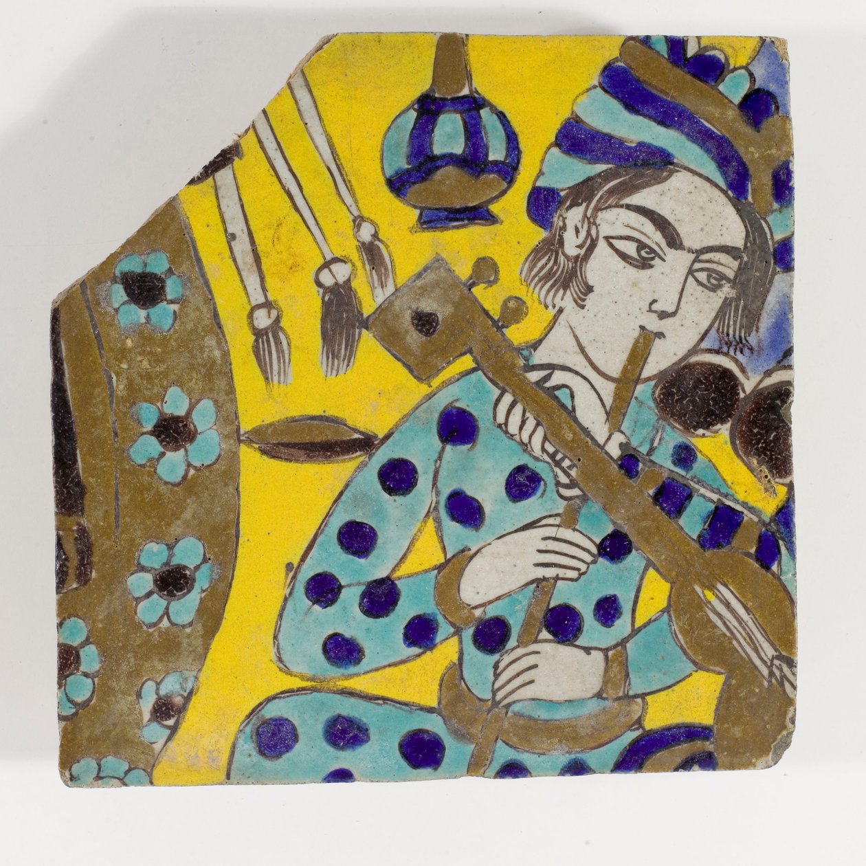 Piastrella di ceramica cuerda seca della Persia safavide del tardo XVII secolo raffigurante un uomo che suona il flauto con un turbante da Persian School