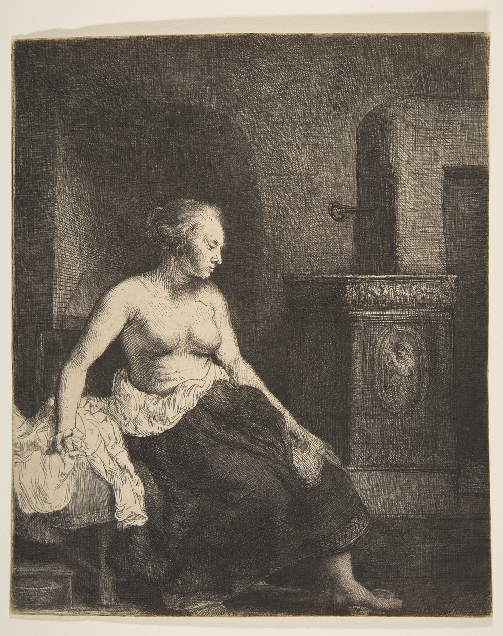 Donna seduta mezza vestita accanto a una stufa da Rembrandt van Rijn