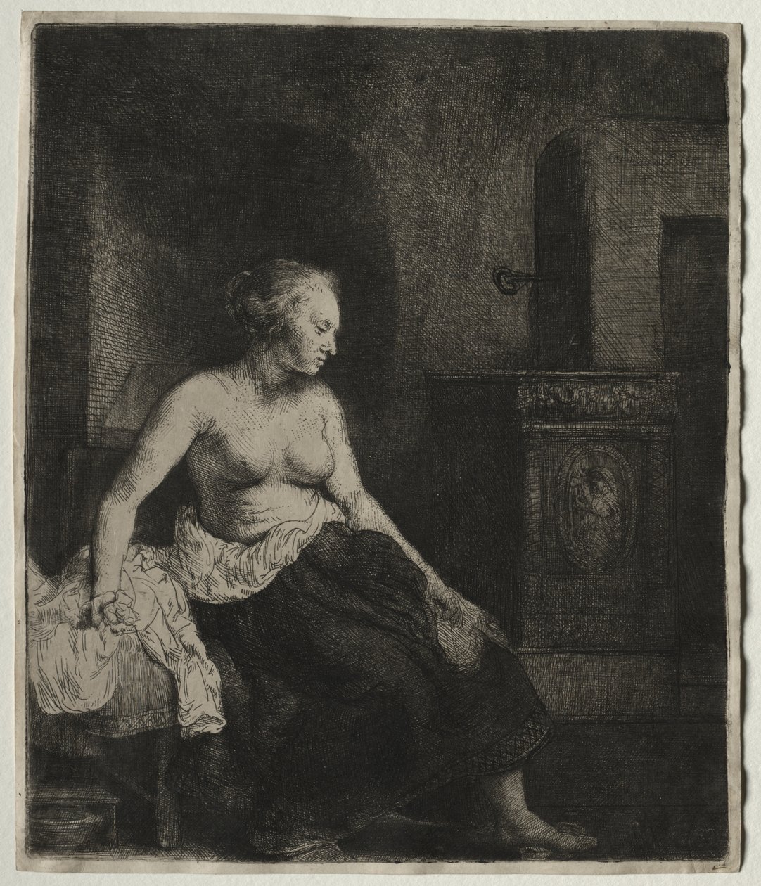 Donna seduta mezza vestita accanto a una stufa da Rembrandt van Rijn