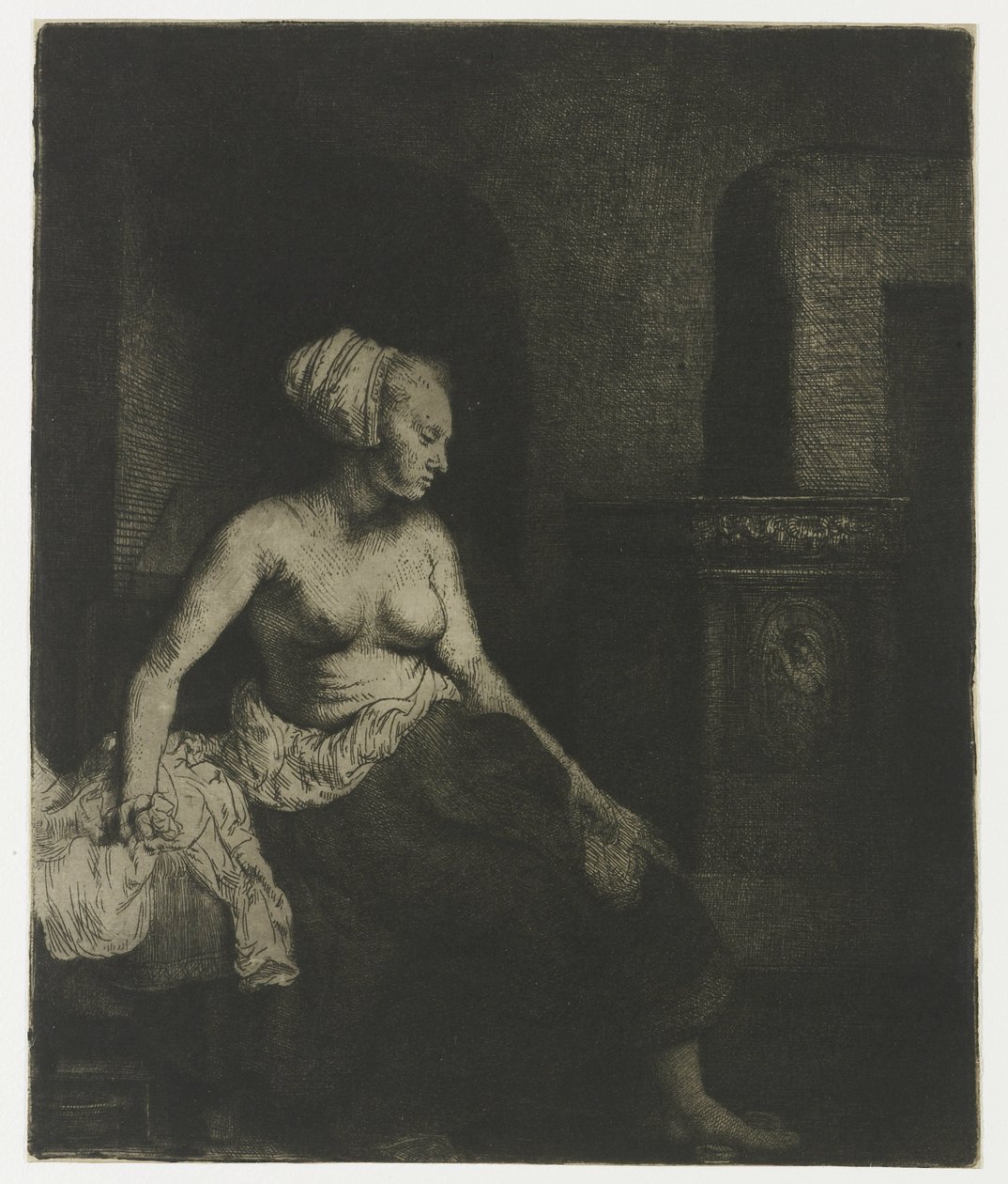 Donna seduta mezza vestita accanto a una stufa da Rembrandt van Rijn