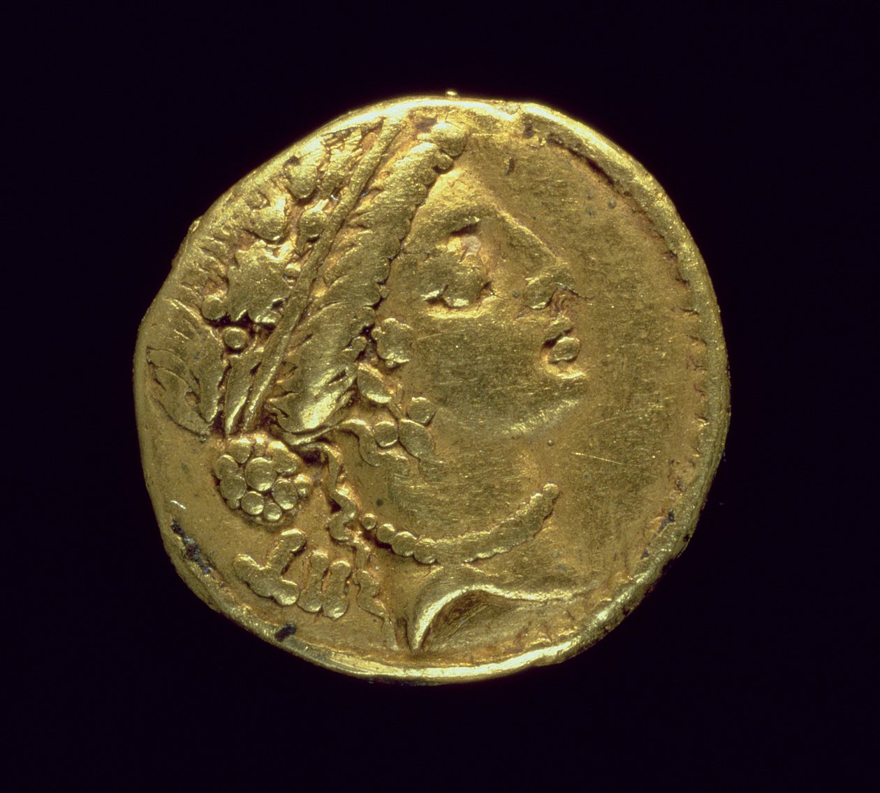 Aureo (dritto) coniato da Giulio Cesare (110-44 a.C.) raffigurante una testa femminile a destra con corona di quercia e diadema da Roman