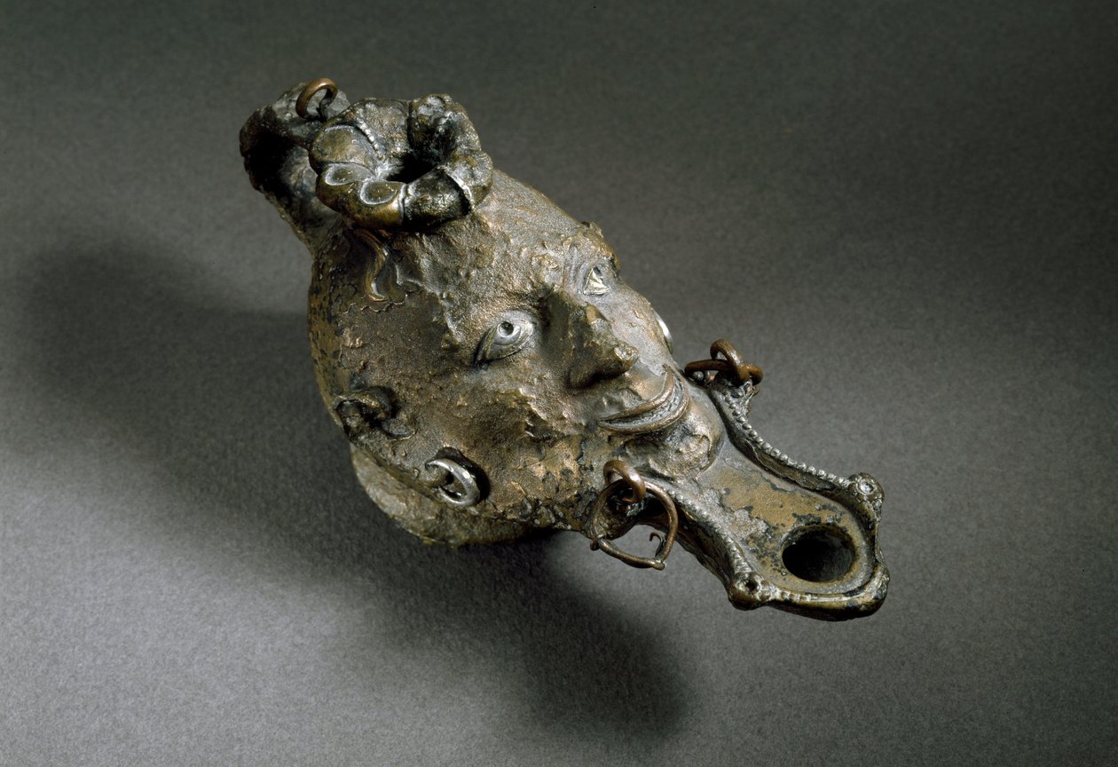 Arte romana: lampada ad olio in bronzo a forma di volto. I-II secolo d.C. Spagna, Museo di Ampurias (Empurias) da Roman
